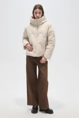 Campera puffer de cuello alto con capucha integrada, cierre frontal y diseño acolchado con costuras onduladas. Presenta mangas largas y bolsillos laterales.