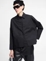 Camisa negra de algodón con botones en la parte delantera y cortes geométricos.