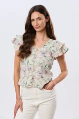 Camisa de lino estampada con diseño floral en tonos lila y verde, mangas cortas con volados y cierre frontal con botones.