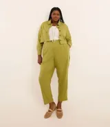 Pantalón zanahoria color verde oliva confeccionado en viscolino, con cintura elástica en la espalda, cierre tradicional, bolsillos laterales y pliegues delanteros.