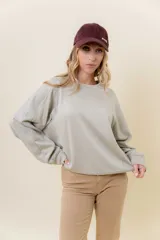 Buzo de manga larga color verde claro, con cuello redondo y calce relajado.