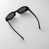 Lentes de sol con armazón ovalado de acetato traslúcido en tono gris oscuro y lentes oscuros.