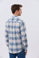 Camisa de lino de manga larga con diseño a cuadros en tonos celeste, blanco y tostado, cuello camisero y cierre frontal con botones.