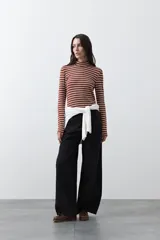 Polera de cuello alto con diseño de rayas horizontales en color azul marino sobre fondo blanco, confeccionada en tejido de punto con mangas largas.