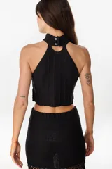 Top halter negro confeccionado con una mezcla de cuero y tejido artesanal, con diseño geométrico de rombos unidos por costuras de crochet y dobladillo en punta.