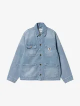 Campera de trabajo tipo chore coat Carhartt modelo Michigan, confeccionada en denim negro con costuras en contraste. Presenta cierre frontal con botones metálicos grabados, cuello clásico y cuatro bolsillos frontales, uno de ellos con etiqueta de la marca.