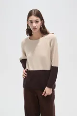 Sweater de punto con diseño color block, combinando azul marino en la parte superior y celeste en la inferior. Presenta cuello redondo a la base y mangas largas con terminación en puño.