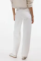 Pantalón jean de tiro alto en denim de algodón blanco, con diseño curvo de piernas con volumen y cinco bolsillos clásicos.
