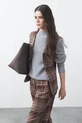 Chaleco de sastrería con estampado de cuadros en tonos tierra, diseño estructurado con escote en V y cierre frontal con botones.