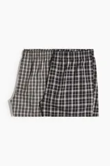 Pack de dos calzoncillos tipo boxer de tela suave, con cintura elástica y bragueta de botones. Ambos presentan diseños a cuadros en tonos blanco y negro.