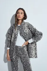 Sobrecamisa de jean con estampado animal print abstracto en tonos gris y blanco, de corte relajado, cuello camisero, cierre frontal con botones metálicos y bolsillos frontales.