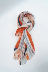Pañuelo rectangular de tela ligera con estampado de rayas verticales en tonos naranja, azul, gris y crudo, con detalles de líneas discontinuas.