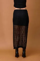 Falda larga de encaje color marrón, con diseño de tiro alto y corte recto. Presenta una capa superior opaca y una capa inferior con transparencias que llega hasta los tobillos.
