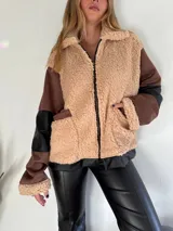 Campera con cierre frontal, de piel sintética color beige con detalles en marrón y negro.