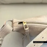 Bandolera de cuero color beige con correa ajustable y cierre superior con cremallera.