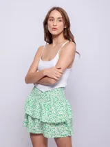 Falda corta con volados y estampado floral en tonos verde y blanco. Presenta cintura fruncida con elástico.