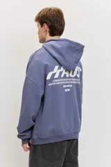 Canguro de friza color azul acero, con capucha, bolsillo tipo canguro y estampado gráfico en el pecho con texto en blanco.