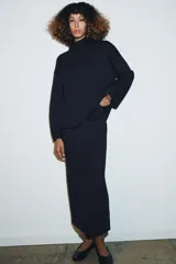Falda midi de punto con tiro alto y cintura elástica, de corte ajustado y diseño minimalista.