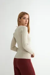 Sweater de punto fino en color negro, con cuello redondo y mangas largas, de corte ajustado al cuerpo.