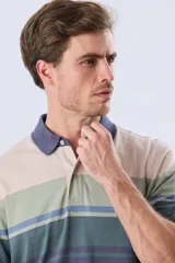 Remera polo de manga corta con diseño a rayas horizontales en tonos beige, celeste, rosado, azul marino y verde. Cuenta con cuello polo y cierre frontal con botones.