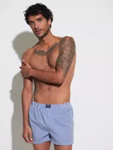 Bóxer de algodón blanco con estampado de flores pequeñas color celeste, con cintura elástica y logo de la marca en el centro.