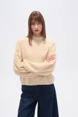 Polera de punto color marrón con destellos brillantes, cuello redondo, mangas largas abullonadas y diseño holgado.