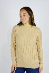 Sweater de punto color beige, con diseño de trenzas, cuello redondo y mangas largas.