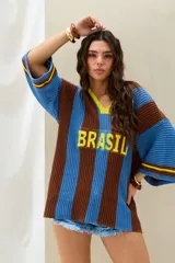 Remerón tejido de punto en rayas verticales marrones y celestes, con cuello en V amarillo, mangas 3/4 y la inscripción 'BRASIL' en el frente.