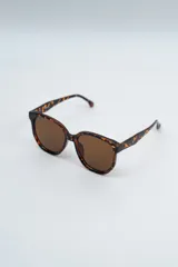 Lentes de sol con armazón de carey en tonos marrones y negros, con cristales oscuros.