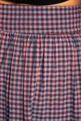 Falda midi de algodón con estampado de cuadros gingham en tonos rosa y azul marino. Tiene corte acampanado, cintura alta y botonadura frontal.