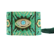 Pulsera tejida con pequeñas cuentas de colores verde, dorado, negro y celeste. Diseño con ojo turco al centro.