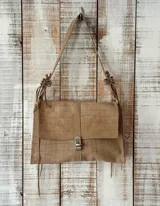 Cartera bandolera color tostado con diseño de efecto cocodrilo, solapa frontal con cierre metálico, detalles de tiras colgantes y correa de hombro ajustable con nudos decorativos.
