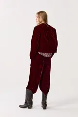 Pantalón de terciopelo color borgoña, de tiro alto, con cintura elástica en la espalda, cierre frontal, bolsillos laterales y piernas anchas.