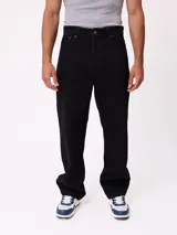 Jean de corte slouchy fit, confeccionado en denim de algodón color azul medio. Presenta diseño de cinco bolsillos, cierre frontal con botón y costuras reforzadas en tono contrastante.