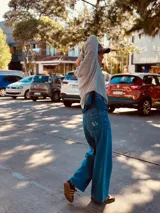 Pantalón de jean ancho de color azul, con bordado de las iniciales AW en el bolsillo trasero.