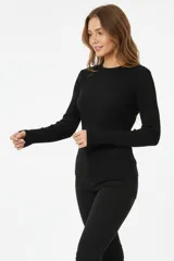 Remera de manga larga confeccionada en tejido de punto canalé, con cuello redondo y ajuste al cuerpo.