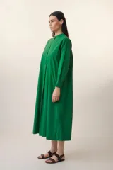 Vestido largo verde esmeralda de algodón, con cuello mao, mangas largas con puños abotonados, pechera con botones y corte evasé.