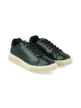 Sneakers de mujer con diseño de imitación piel de reptil en tonos verdes, cordones negros y suela gruesa texturizada de color marfil.