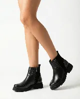 Bota corta de cuero color marrón, con diseño que combina cuero liso y sectores con textura grabada. Presenta una base robusta con taco medio y cierre lateral para facilitar el calce.