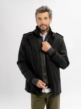Tapado de paño negro con pechera de nylon desmontable, cierre frontal y puños tejidos acanalados.