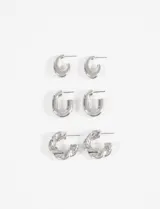 Set de tres pares de aros tipo argolla en color plateado con diferentes diseños: un par pequeño liso, un par mediano liso y un par con textura retorcida.