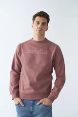 Buzo de felpa color rosa con logo estampado, cuello redondo, mangas largas y puños.