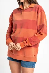 Sweater tipo polo de algodón peinado con diseño de rayas horizontales en tonos rojizos y terracota, cuello camisero y mangas largas con puños.