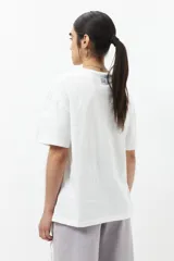 Remera blanca de algodón con cordones ajustables a los laterales, manga corta y cuello redondo.