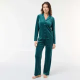 Conjunto de pijama de dos piezas en terciopelo color verde oscuro, compuesto por una camisa de manga larga con cuello solapa y botones frontales, y un pantalón largo de corte recto.