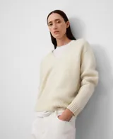 Sweater de punto para mujer confeccionado en una mezcla de lana merino y alpaca. Presenta un diseño de línea redondeada con cuello en V, manga larga y acabados en canalé en puños y bajo. El tejido es ligero, abrigado y de textura suave con pelo.