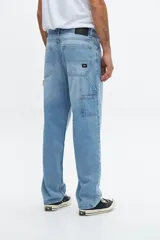 Pantalón de jean celeste, de corte amplio y tiro medio, con bolsillos delanteros y traseros, y presilla para herramientas en la pierna derecha.