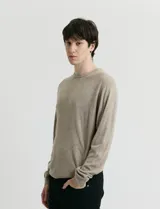 Sweater de tejido de punto con escote redondo y manga larga. Presenta un diseño clásico con detalles de terminación en sisas y cuello.