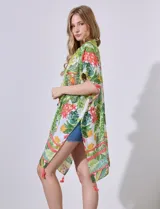 Kimono tejido con estampado de hojas y flores en tonos verdes, amarillos y rosados. Tiene mangas japonesas y terminación con borlas rosadas.
