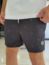 Short de baño negro con pequeño estampado rojo repetido y cordón ajustable en la cintura.